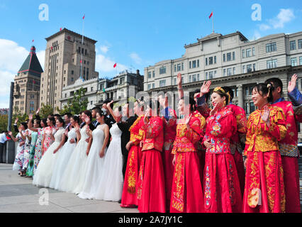 15 Paare statt Gruppe Hochzeiten durch den Fluss Huangpu, den der 70. Jahrestag der Gründung der VR China in Shanghai, China, 19. September 2019 zu feiern. Stockfoto