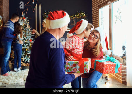 Großeltern geben Sie ein Geschenk zu ihrem Enkel im Haus zu Weihnachten. Stockfoto