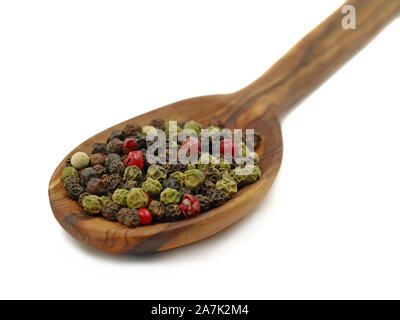 Nahaufnahme Löffel aus Holz mit Pfeffer mischen auf weißem Hintergrund. Schwarz, Rot, Grün und weiße Pfefferkörner Makroaufnahme Stockfoto