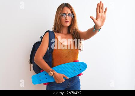 Junge rothaarige Studentin Frau mit Rucksack und Skateboard über isolierte Hintergrund mit der offenen Hand tun, STOP-Schild mit schweren und zuversichtlich Express Stockfoto