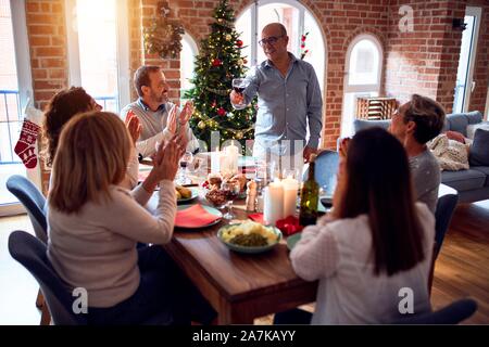 Familie und Freunde speisen zu Hause feiern Weihnachten mit traditionellem Essen und Dekoration, wodurch ein Toast für das neue Jahr die besten Wünsche Stockfoto