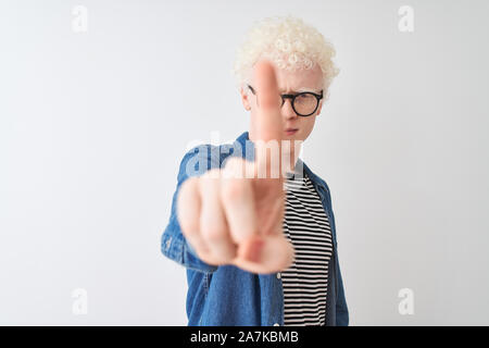 Junge albino blonder Mann tragen Jeanshemd und Gläser über isoliert weißer Hintergrund zeigt mit dem Finger auf und verärgerten Ausdruck, keine Geste Stockfoto