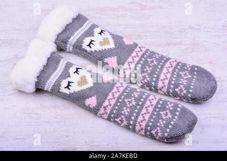 Ein Paar gestrickte Wollsocken auf weißem Holz- Hintergrund. Stockfoto