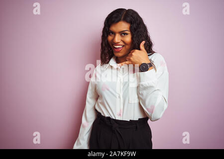 Transsexuelle transgender Geschäftsfrau stehend über isolierte rosa Hintergrund lächelnd tun Telefon Geste mit der Hand und der Finger wie im Gespräch auf der Tel. Stockfoto