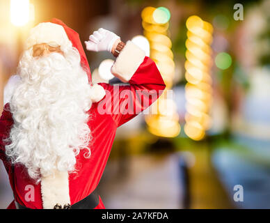 Mittleres Alter stattlicher Mann mit Santa Claus Kostüm und Bart ständigen zurück reicht, müde und entspannt, schläfrig und Gähnen für am frühen Morgen Stockfoto