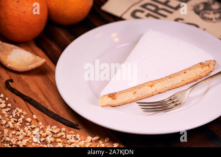 Teil der hausgemachten italienischen Ricotta Käsekuchen mit gehackten kandierten Orangenschalen und bestreut mit Puderzucker auf Holz- Hintergrund. Italienische recip Stockfoto