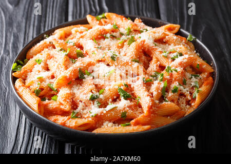 Penne Alla Vodka ist ein klassisches italienisches Pastagericht mit Penne in einer cremigen Soße aus Tomaten und Wodka zu schließen, in einen Teller auf dem Tisch. Horizontale Stockfoto