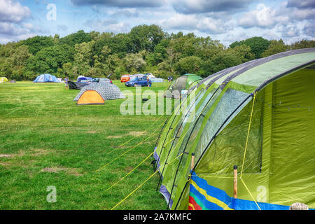 Norden, England - 29.August 2018: Bunte Zelte auf einem grünen Feld Campingplatz unter blauen bewölkten Himmel, mit Campingplatz und ihr Zelt Stockfoto