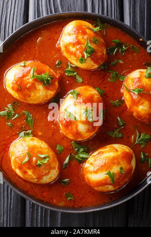 Traditionelles indisches Essen Eier Curry in pikanter Sauce close-up in einem Teller auf dem Tisch. Vertikal oben Ansicht von oben Stockfoto