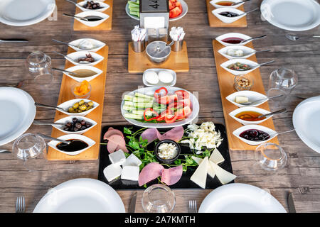 Vorbereitung auf ein reichhaltiges mediterranes Frühstück für eine Gruppe. Stockfoto