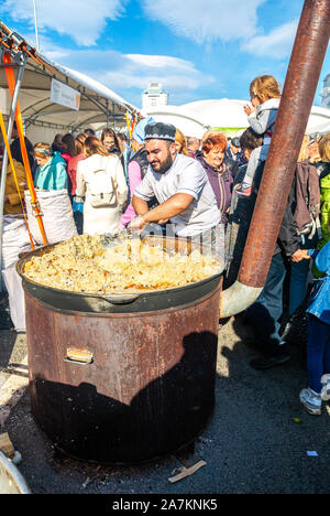 Samara, Russland - Oktober 5, 2019: Kochen appetitlich traditionelles orientalisches Pilaw in einem großen Kessel im Freien während des Urlaub Stockfoto