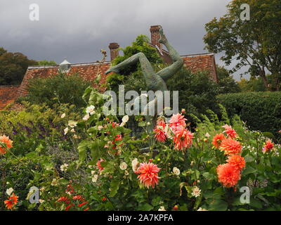 Chenies Manor Garden am Ende des Sommers. Jonathan Hateley Skulptur unter den Fenchel seedheads, Dahlie 'Labyrinth', und Stockrosen mit hohen Bäumen. Stockfoto