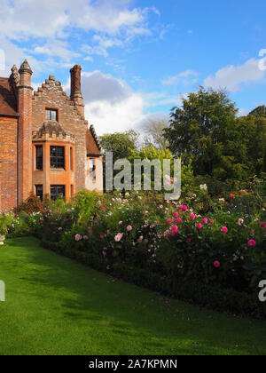 Chenies Manor House mit Blick auf South West, die durch die Grenzen mit bunten Pink Dahlia Sorten und Kosmos auf eine feine September Abend umrahmt. Stockfoto