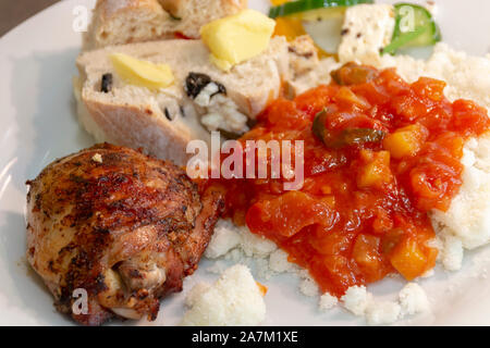 Eine Nahaufnahme eines delious Südafrikanischen Braai oder Barbecue Lunch, Huhn, mealie Meal mit Soße, frisches Brot und Salat Stockfoto