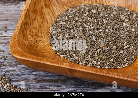 Chia Samen in eine hölzerne Schüssel auf einem hölzernen Hintergrund Stockfoto