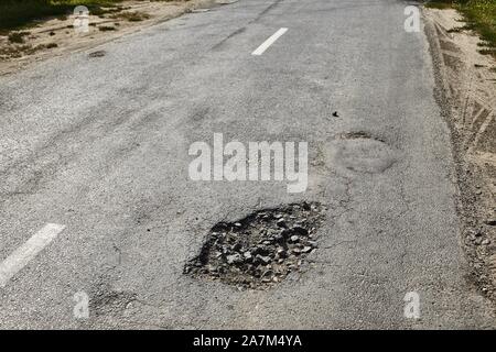 Schlaglöcher auf der Straße Stockfoto