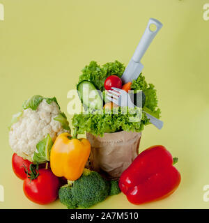 Bio Gemüse broccoli Gurken Paprika Äpfel in Braun aus Kraftpapier grocery Bag auf gelben Hintergrund. Gesunde Ernährung Ballaststoffe vegan Plas Stockfoto