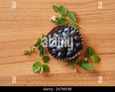 Heidelbeeren im Törtchen auf einem Holztisch mit grünen Stockfoto