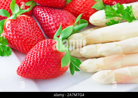 Spargel und Erdbeeren auf weißem Hintergrund Stockfoto