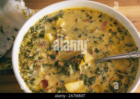 Nahaufnahme aus einer Schüssel italienische Suppe mit Kartoffeln, Würstchen, rote Paprika und Sahne gemacht. Zuppa Toscana. Stockfoto