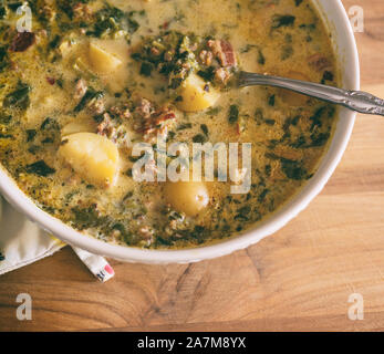 Nahaufnahme aus einer Schüssel italienische Suppe mit Kartoffeln, Würstchen, rote Paprika und Sahne gemacht. Zuppa Toscana. Stockfoto