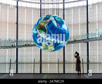 Tokyo, Japan - 12 Okt 2018: Eine Frau wird ein Bild von Geo-Cosmos, eine riesige Kugel im Inneren Miraikan, Japans nationale "Museum". Stockfoto