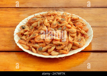 Kleine gekochte Garnelen in einer weißen Schüssel auf dem Tisch Stockfoto
