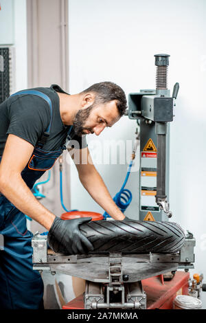 Service Arbeitnehmer ändern Motorrad Reifen auf eine spezielle Ausrüstung für die Reifenmontage in der Werkstatt für Motorrad, Reparatur Stockfoto