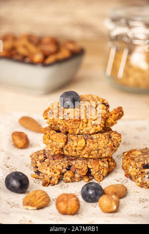 Hausgemachte Haferkleie cookies mit Blaubeeren, Haselnüsse, Mandeln und Walnüsse. Gesundes Essen. Vertikale Komposition. Stockfoto