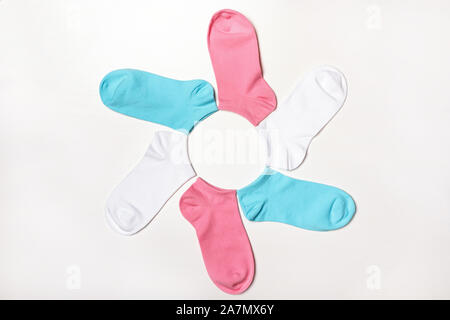 Mehrfarbige kurze Socken in die Form einer Blume liegen auf einem weißen Hintergrund. Ansicht von oben. Stockfoto