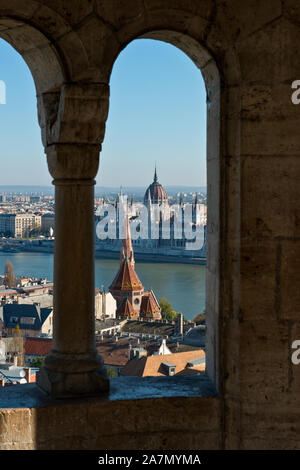 Blick durch das Fenster von Fisherman's Bastion mit Blick auf die Donau und das ungarische Parlament Gebäude. Stockfoto