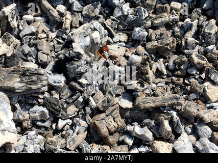 Schöne rote Flamme von Schicht Holz, dunkel grau schwarz Kohlen in Metall brazier. Holz Brennen in der brazier auf hellen gelben Flamme. Flammen Feuer Vorbereitung Stockfoto