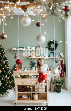 Süße kleine Mädchen mit Weihnachtsgeschenk zu Hause Stockfoto