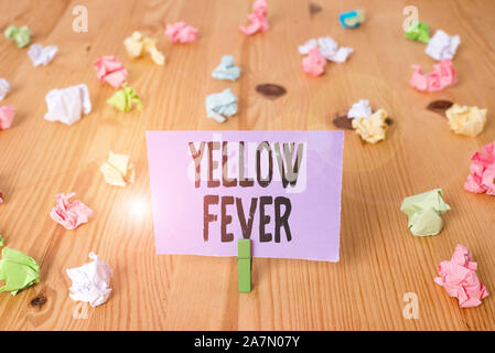 Schreiben Hinweis, Gelbfieber. Business Konzept für tropischen Virus Erkrankung, die Leber und die Nieren Farbige zerknittertes Papier Holzboden ba Stockfoto