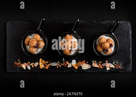 Mini Knödel auf einen schönen Teller auf einem dunklen Hintergrund. Essen Konzept für die Verpflegung. Low Key, copy Space Stockfoto