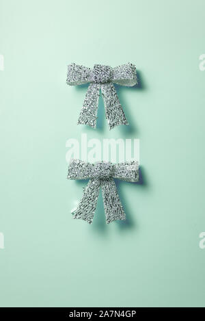 Urlaub Dekorationen Sammlung, zwei glänzenden silbernen Schleife auf blauem Hintergrund. Konzept für Weihnachten und Feiertage. Stockfoto