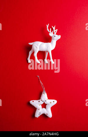 Weiße rentier Spielzeug mit Weihnachten Stern auf rotem Hintergrund. Weihnachten oder Neujahr minimalen Begriff. Stockfoto