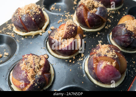 Pflaume Gebäck mit zerbröselten Keksen bereit im Ofen gebacken zu werden. Stockfoto