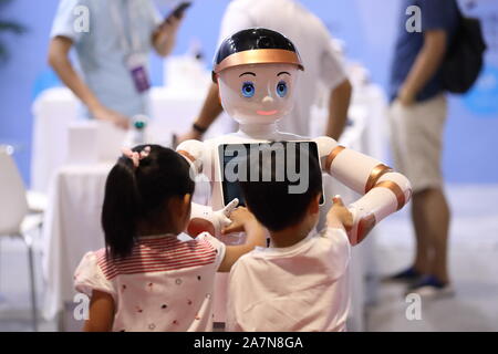 Kinder interagieren mit einem intelligenten Roboter während der 2019 Wort Robot Konferenz (WRC) in Peking, China, 20. August 2019. Stockfoto