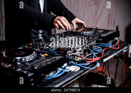 DJ spielt live und Mischen von Musik auf Drehsockel Konsole im Stadium der Night Club. Disk Jokey Hände auf einem Mischpult Station im Club Party. DJ-Mixer Stockfoto