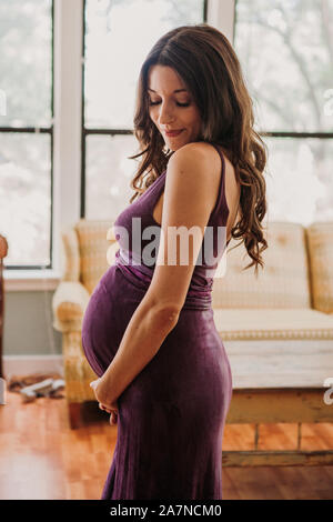 Schöne schwangere Frau in Lila Kleid Stockfoto