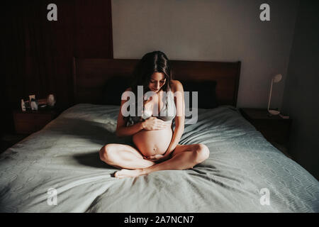 Schwangere Frau im Bett Stockfoto
