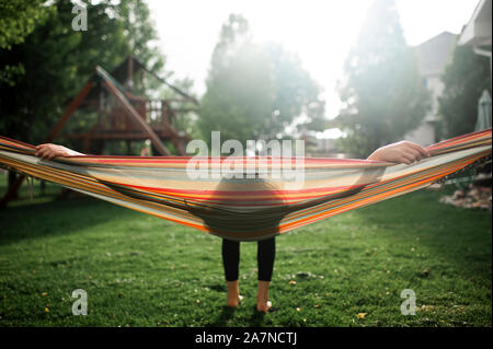 Tween girl eine Pause beim Schwingen in der Hängematte im Hinterhof Stockfoto