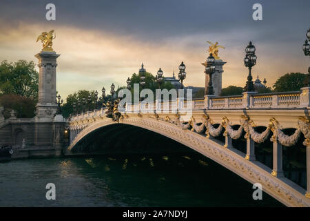 Pont Alexandre III mit Petit Palais im Hintergrund und der Seine im Vordergrund bei Sonnenuntergang Stockfoto