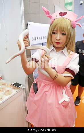 Ein cosplayer hält eine weiße Schlange bei Pet Fair Asia 2019 in Shanghai, China, 23. August 2019. *** Local Caption *** fachaoshi Stockfoto