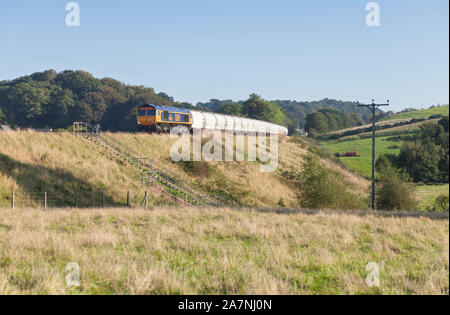 GB Railfreight Class 66 Diesel Lokomotive, wie auf der Tyne Tal Bahnstrecke in Cumbria mit einem Güterzug mit bulk Aluminiumoxid Stockfoto