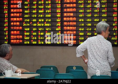 Zwei ältere Personen beobachten Sie die Börse mit einem Makler Unternehmen in Nanjing in der ostchinesischen Provinz Jiangsu, 26. August 2019. Stockfoto