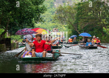 Tam Coc, Vietnam, 16. Oktober 2019: asiatische Touristen reisen auf einem Boot Tour durch die Tropfsteinhöhlen von Ninh Binh an einem sonnigen Tag Stockfoto