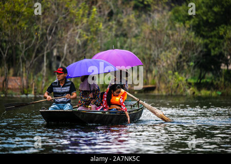 Tam Coc, Vietnam, 16. Oktober 2019: asiatische Touristen reisen auf einem Boot Tour durch die Tropfsteinhöhlen von Ninh Binh an einem sonnigen Tag Stockfoto