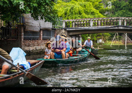 Tam Coc, Vietnam, 16. Oktober 2019: asiatische Touristen reisen auf einem Boot Tour durch die Tropfsteinhöhlen von Ninh Binh an einem sonnigen Tag Stockfoto